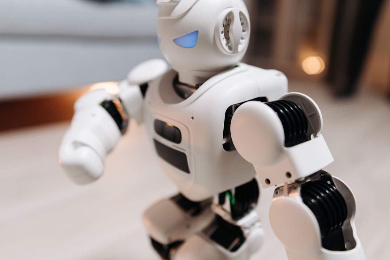 Services Close-up of a futuristic toy robot with blue eyes, showcasing modern technology indoors.