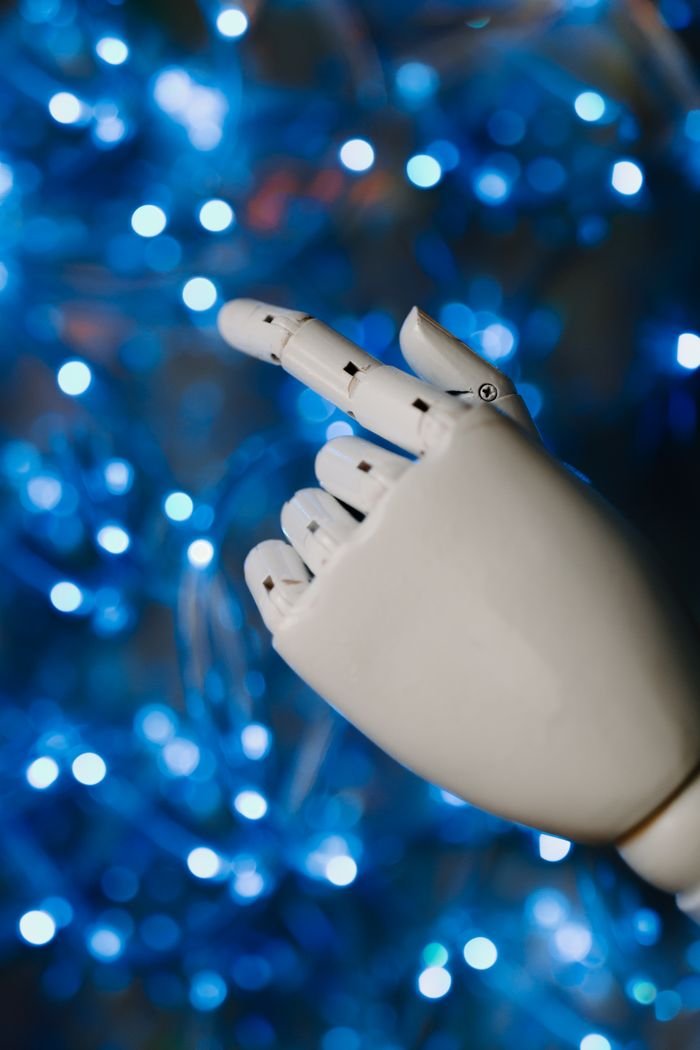 About Close-up of a robotic hand with glowing blue bokeh background, symbolizing advanced technology.